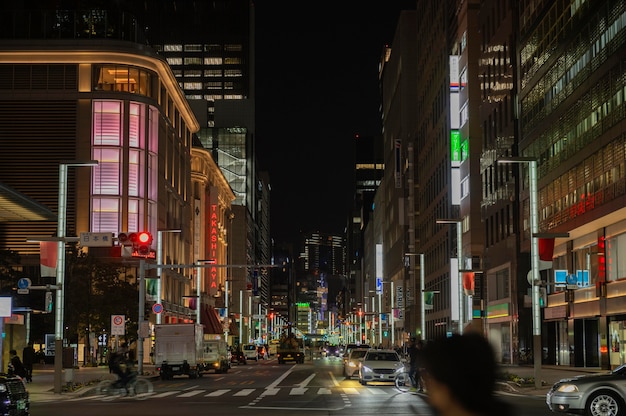 Ciudad de Japón por la noche con gente en la calle.