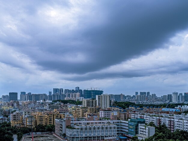 Ciudad moderna y un cielo lleno de nubes oscuras.