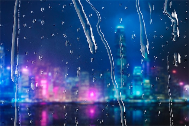 Ciudad de noche a través de la ventana con gotas de lluvia.