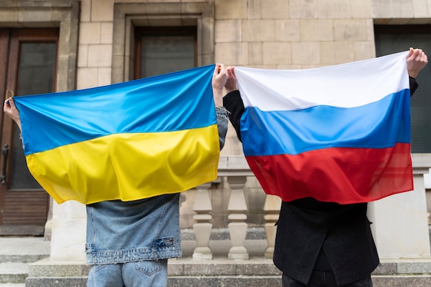 Foto gratuita ciudadanos de vista posterior con bandera rusa y ucraniana