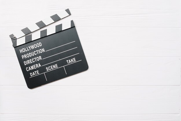 Clapperboard en la mesa de madera blanca