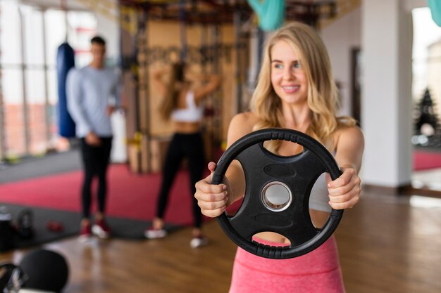 Clase de fitness mujer joven con pesas