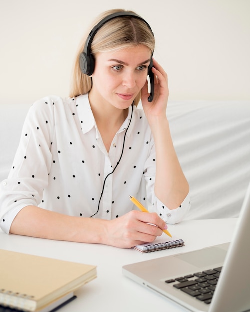 Clases en línea con estudiante sosteniendo sus auriculares