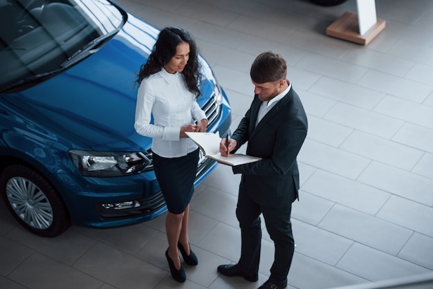 Foto gratuita clienta y empresario barbudo con estilo moderno en el salón del automóvil