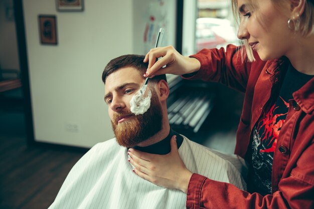 Cliente durante el afeitado de barba en peluquería.