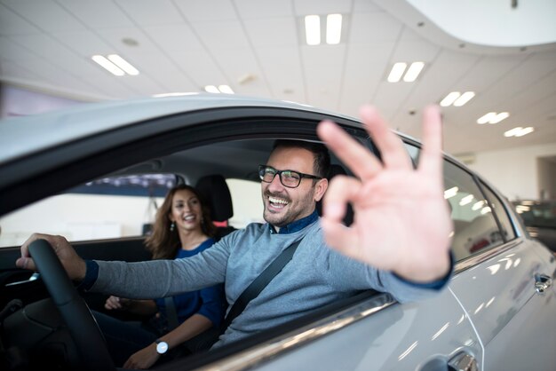 Cliente feliz comprando un coche nuevo en el concesionario