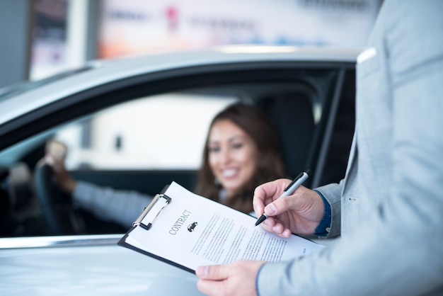 Foto gratuita cliente feliz comprando un coche nuevo