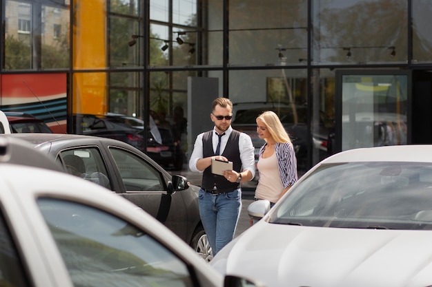 Foto gratuita cliente feliz en concesionario de automóviles con vendedor