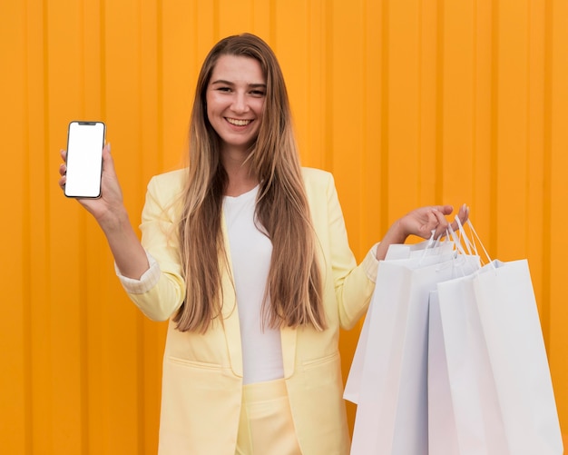 Cliente joven vistiendo ropa amarilla y sosteniendo un teléfono