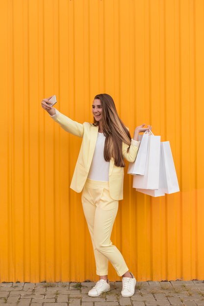 Cliente joven vistiendo ropa amarilla y tomando un selfie