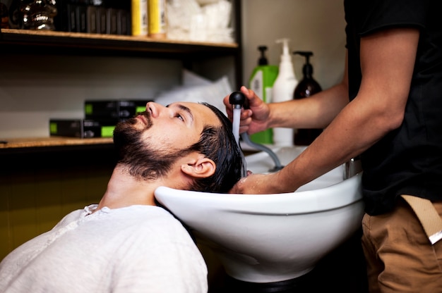 El cliente se lava después del corte de pelo