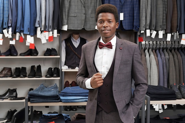 Cliente masculino de la tienda en traje gris, mirando a cámara.