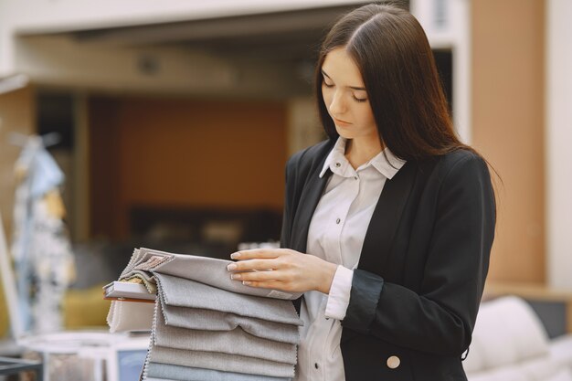 Cliente mujer buscando tela hermosa en la tienda de cortinas