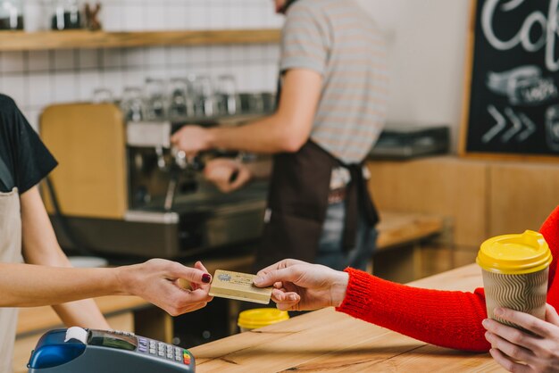 Cliente pagando por bebidas en café