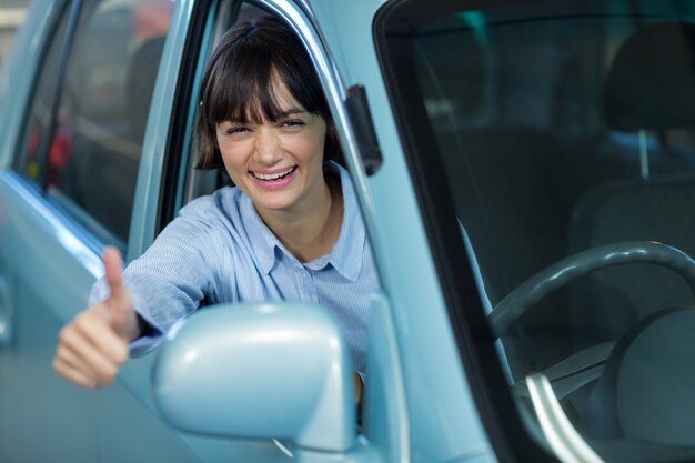 Cliente que muestra el pulgar hacia arriba mientras se conduce un coche