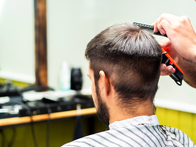 El cliente recibe un nuevo corte de pelo desde atrás