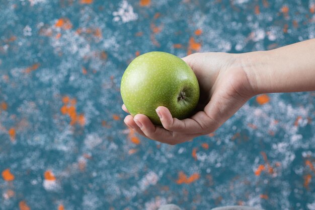 Cliente sosteniendo una manzana en la mano.