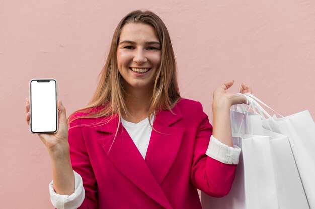 Cliente vistiendo ropa de moda y sosteniendo la vista frontal del teléfono móvil