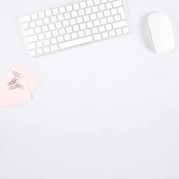 Clips de papel y notas adhesivas cerca del teclado y el mouse