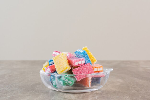 Cloe foto de caramelos de colores caseros en un tazón sobre gris.