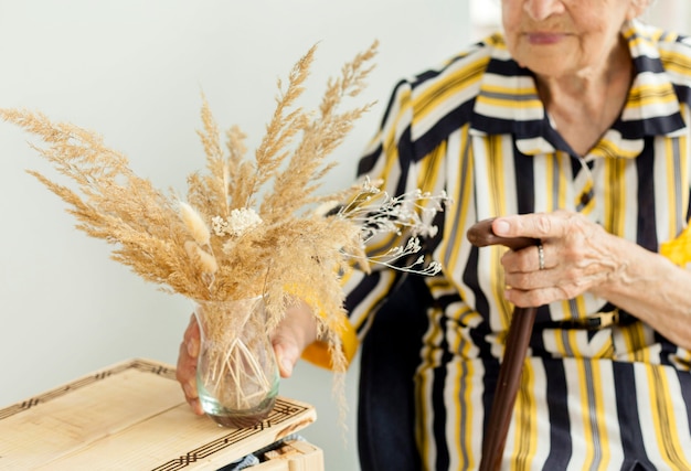 Foto gratuita close-up abuela sosteniendo flores