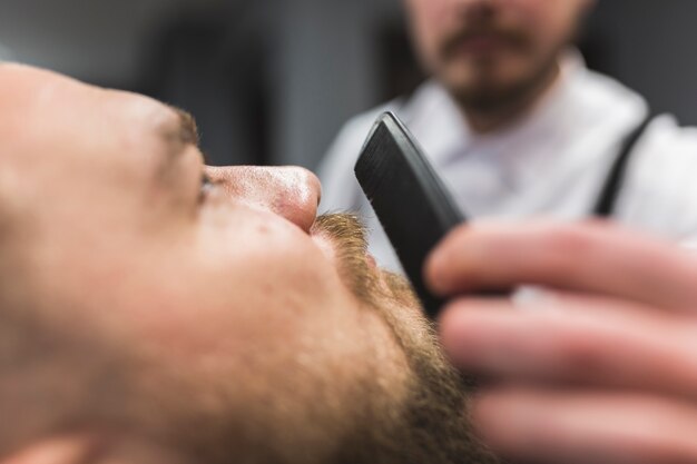 Close-up barbero peinado bigote del cliente