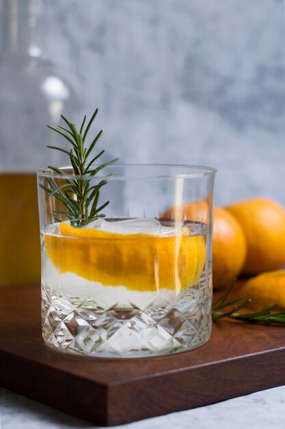 Close-up bebida alcohólica con romero y naranja