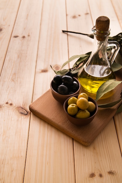Close-up botella de aceite de oliva y aceitunas