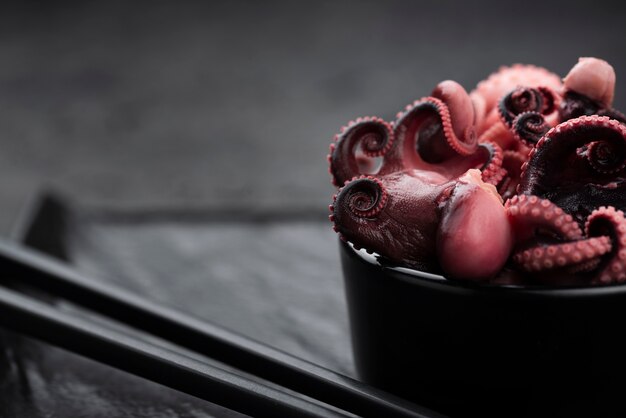 Close-up de calamares en un tazón con palillos
