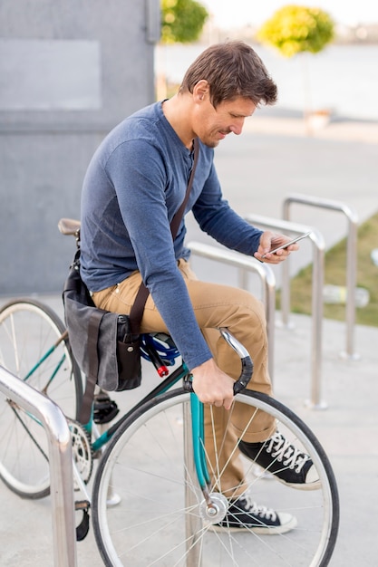 Close-up casual macho asegurando su bicicleta