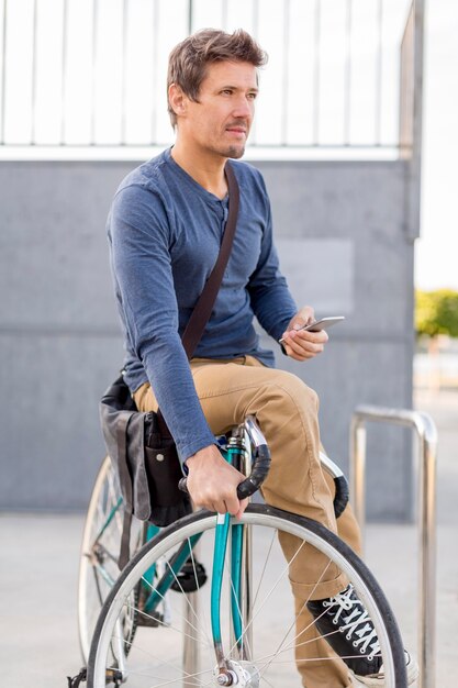 Close-up casual macho asegurando su bicicleta