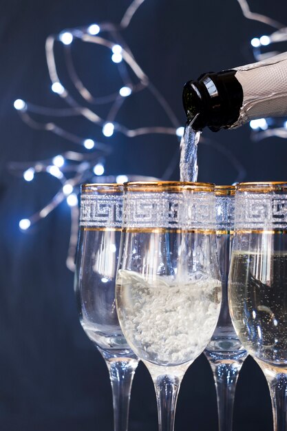 Close-up de champagne vertiendo en el vaso por la noche
