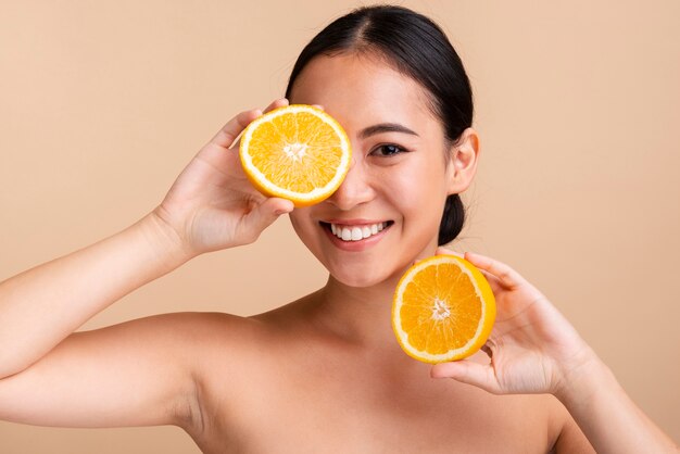 Close-up chica asiática con naranja