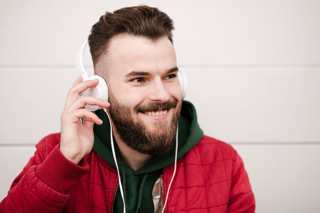 Close-up chico sonriente con auriculares y barba