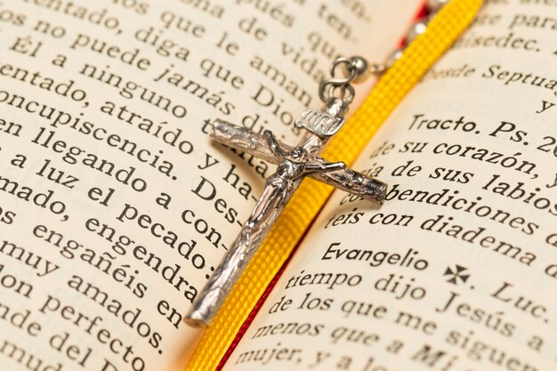 Close-up collar cruz y libro sagrado