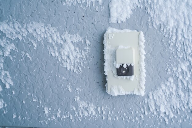 Close-up Doorbell botón cubierta con nieve blanca.