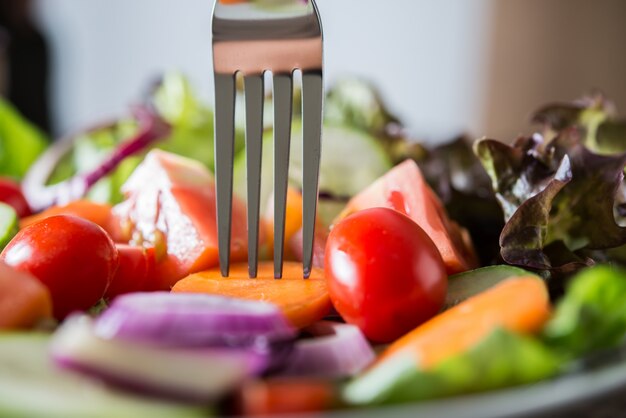 Close up de ensalada de verduras frescas en el recipiente con fondo de madera rústica de edad. Concepto de alimentos saludables.