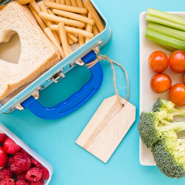 Close-up etiquetado lunchbox cerca de los alimentos