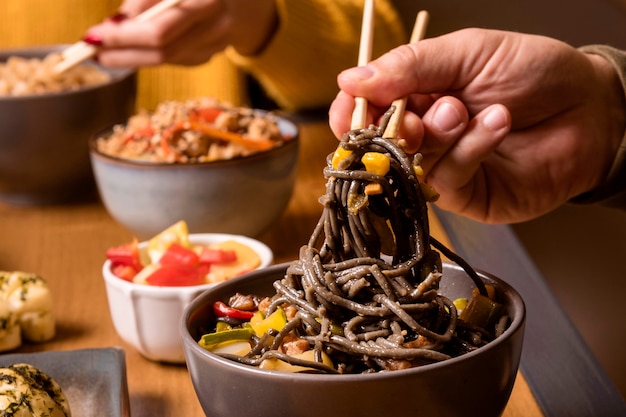 Close-up de fideos en un tazón con otra comida asiática