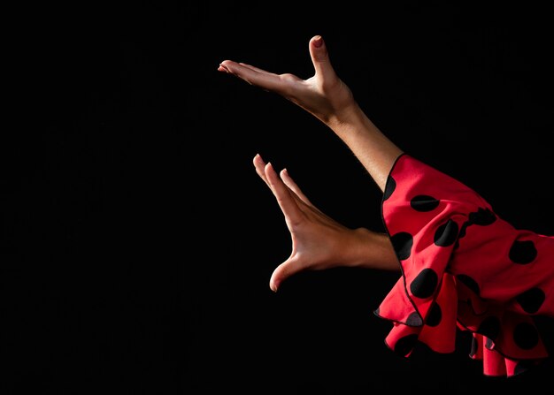 Close-up flamenca moviendo las manos sobre fondo negro