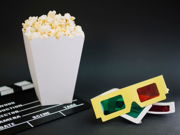 Close-up gafas 3d con caja de palomitas de maíz en la mesa