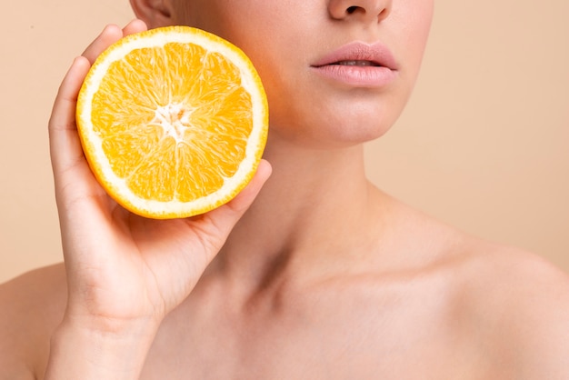 Close-up hermosa modelo con media naranja