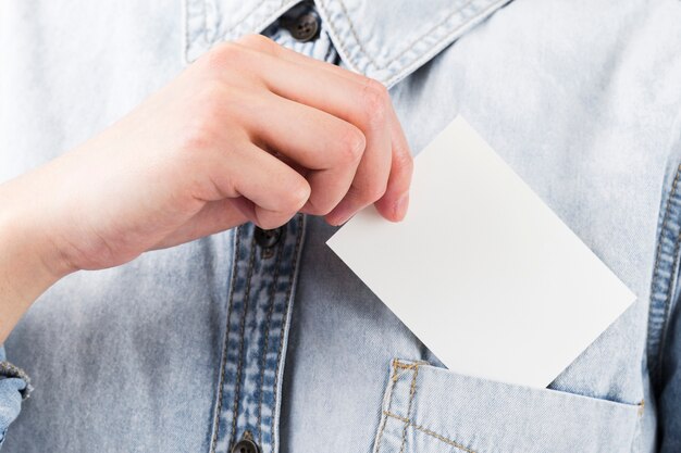Close-up individual dejando la tarjeta de visita en el bolsillo