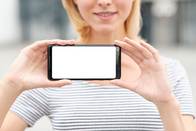 Close-up joven mujer sosteniendo un teléfono