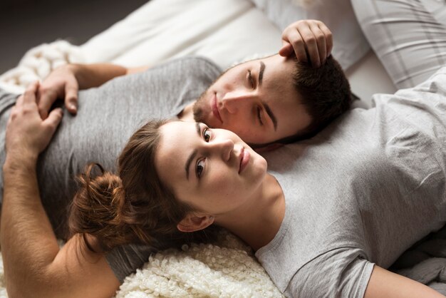 Close-up joven pareja uno al lado del otro en la cama