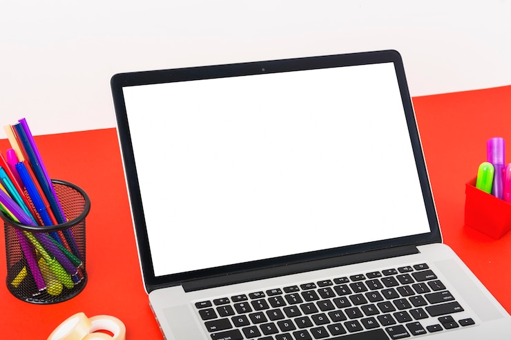 Photo Gratis close-up laptop modern dengan layar putih kosong di atas meja merah
