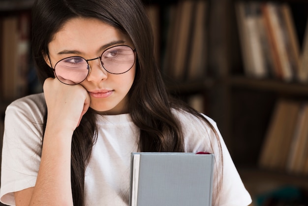 Close-up linda joven sosteniendo un libro