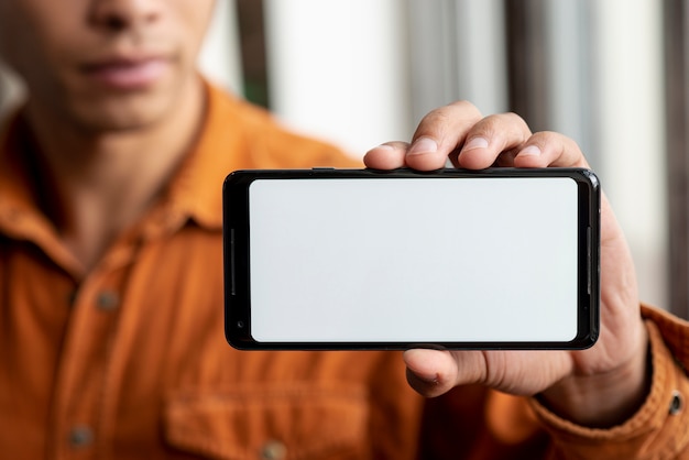 Foto gratuita close-up macho adulto sosteniendo un teléfono