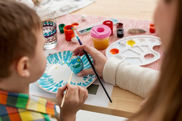 Foto gratuita close-up madre e hijo pintando huevos