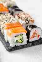 Foto gratuita close-up maki sushi rolls surtido en pizarra